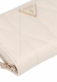 Witte gewatteerde portemonnee met reliëf logo-patroon, voorzien van een goudkleurig driehoekig logo en een ritssluiting met metalen hardware.