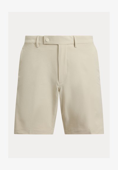 Shorts beige en tissu lisse, avec devant plat, fermeture à boutons et poches latérales. Coupe droite sans motifs apparents.
