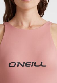 Rosa Badeanzug mit hohem Kragen, glatter Textur und schwarzem "O'Neill"-Logo auf der Brust. Minimalistisches Design ohne zusätzliche Muster.