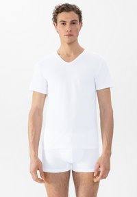 Witte V-hals T-shirt van zachte, lichte stof met korte mouwen. Gladde textuur en eenvoudig ontwerp, aangevuld met slim-fit witte shorts.