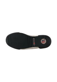 Musta kummist põhja, millel on vertikaalsed sooned, ja sinise ja punase printimisega logo. Beez kanvas ülemine serv on nähtav. Tekstuur on sile.