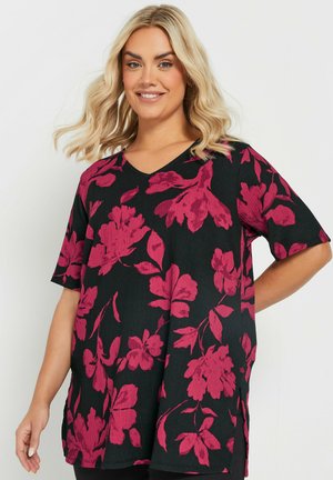 Schwarzes Blumentop mit kurzen Ärmeln, verziert mit rosa Blumenmustern und einem V-Ausschnitt. Der Stoff wirkt strukturiert und hat seitliche Schlitze.