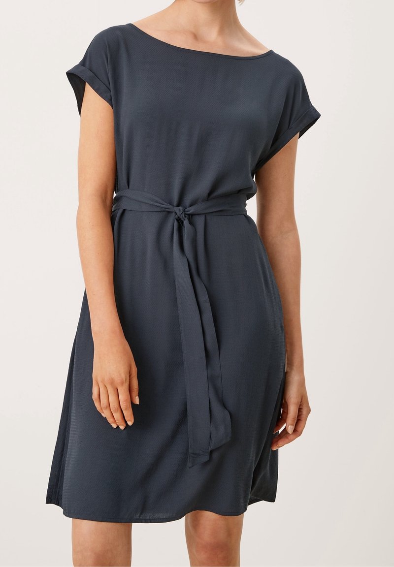 Mörkblå klänning med korta ärmar, en mjuk textur och ett knytbälte i midjan, med en lös passform och knä-lång fåll.