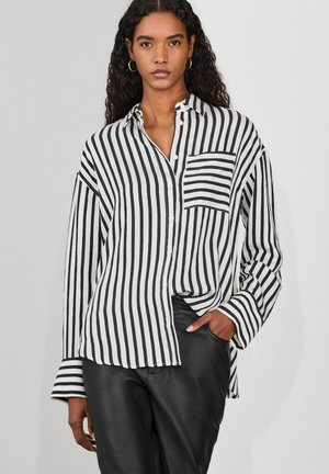 Black and white striped button-up shirt with long sleeves and a chest pocket. Made of lightweight fabric with a relaxed fit.