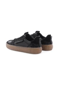 Schwarze Sneakers mit strukturierten schwarzen Stoffabschnitten, glattem Leder und einer dicken, hellbraunen Gummisohle. Schnürdesign, dezentes Branding-Detail.