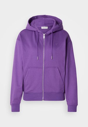 Fialová mikina na zips vyrobená z mäkkého materiálu, s klokankou, kapucňou na šnúrku a diskrétnou výšivkou loga na hrudi.