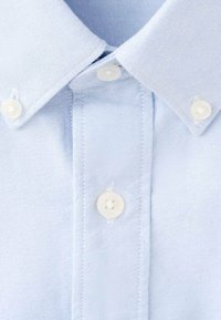 Jasnoniebieska koszula na guziki z kołnierzykiem i białymi guzikami. Tkanina ma gładką teksturę z delikatnym wzorem splotu.