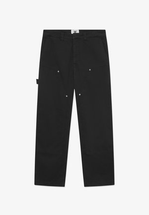 I pantaloni di cotone neri presentano un taglio dritto, cuciture evidenti, tasche laterali e dettagli in metallo sulla parte anteriore.