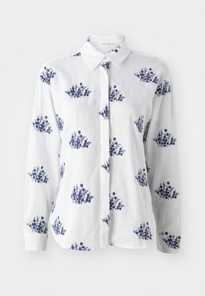 White linen shirt featuring a blue floral print, button-up front, and a classic collar with long sleeves and cuffed wrists.