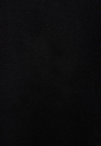 Texture de tissu tricoté noir avec des points fins et réguliers et une légère variation de l'ombrage sur toute la surface.