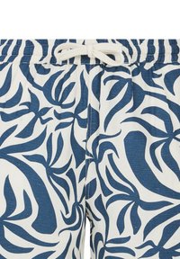 Witte shorts met een blauw bladenpatroon, voorzien van een elastische tailleband en een trekkoord. De stof heeft een gestructureerde, geweven uitstraling.