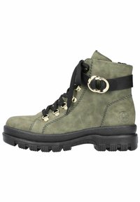 Bottes de cheville en daim vert avec semelle en caoutchouc noire. Les caractéristiques incluent des œillets en métal, des lacets noirs et un détail de boucle circulaire décorative.