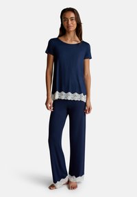 Navyblauwe pyjama's met een korte mouwtop voorzien van een kantafwerking aan de onderrand en bijpassende broeken, ook versierd met kant aan de onderkant.