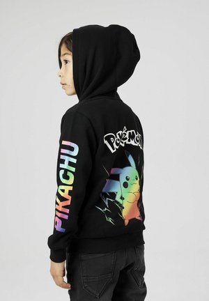 Hoodie noir avec un graphique coloré de Pikachu dans le dos et le texte "Pokémon". Manches longues avec "PIKACHU" en couleurs arc-en-ciel le long d'une manche.