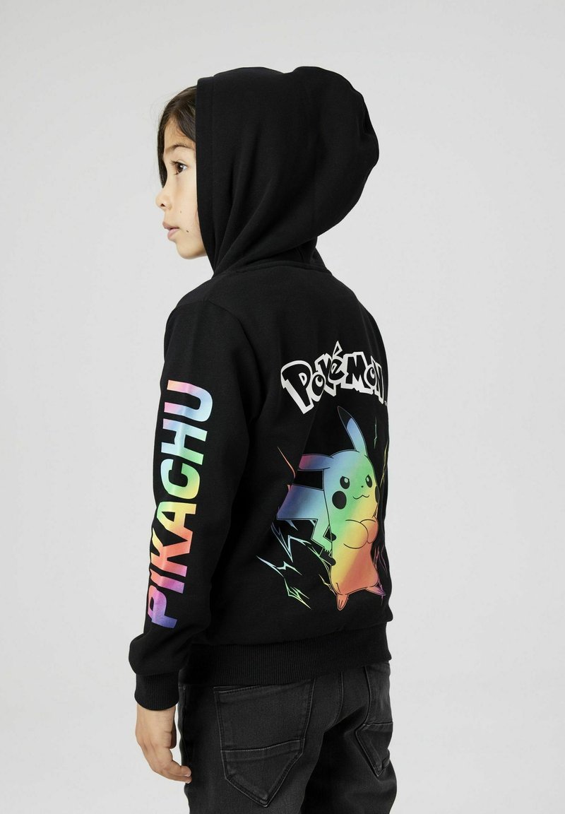 Felpa nera con un grafico colorato di Pikachu sul retro e la scritta "Pokémon". Maniche lunghe con "PIKACHU" in colori arcobaleno lungo un braccio.