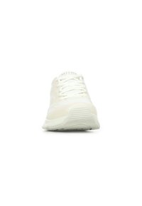 Weiße Sportschuhe mit einer glatten, strukturierten Oberfläche, Schnürverschluss und einer gummierten, gemusterten Laufsohle. Das Material hat einen subtilen Glanz.