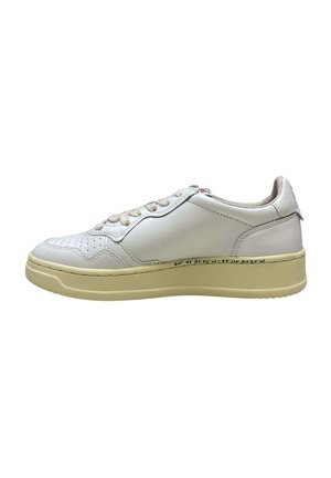 Sneaker bianca in pelle low-top con suola e lacci beige, dettagli di cuciture laterali e numeri di coordinate neri sul bordo della suola.