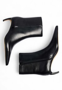 Črne usnjene gležnjače s koničastim nosom, visokim stiletto petam in stranskim zadrgo. Gladka tekstura in eleganten dizajn.