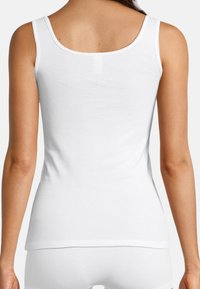 White cotton tank top with a rounded neckline and narrow shoulder straps. Smooth texture, fitted design, with a stitched hem at the bottom.