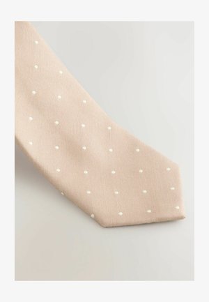 Bežs kaklasaites ar teksturētu virsmu, kas rotāta ar vienmērīgi izvietotiem baltajiem punktiņiem, pakāpeniski sašaurinās līdz smailai daļai. Klasisks dizains gludā audumā.