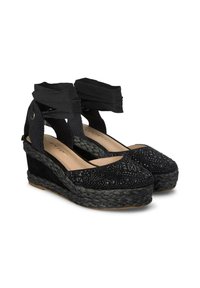 Espadrillas con zeppa nera, dotate di una tomaia in tessuto testurizzato, un sottopiede in iuta intrecciata e cinghie alla caviglia incrociate. Presentano un design a punta arrotondata.