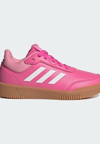 Roze atletske cipele s teksturiranim kožnim gornjim dijelom, mrežastim detaljima, bijelim logom s tri pruge i gumiranim potplatom. Ove cipele imaju i roze vezice.
