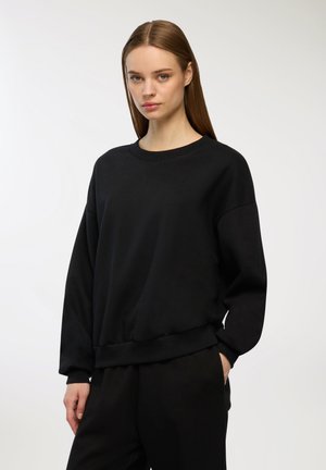 Felpa nera con scollo rotondo e vestibilità comoda, caratterizzata da maniche lunghe e orlo a costine. Realizzata in un tessuto morbido e dalla texture piacevole.