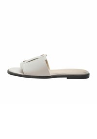 Witte leren slippers met open teen, met een eenvoudig ontwerp en een platte zwarte zool. Getextureerd bovenwerk met minimale accenten.
