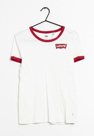 T-shirt blanc Levi's avec col et bord de manches rouges, suspendu à un cintre noir sur fond blanc.