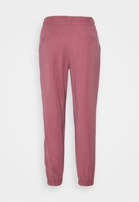 Różowe lekkie spodnie z elastyczną talią, zwężanymi mankietami na kostkach i dwiema tylnymi kieszeniami. Gładka faktura bez widocznych wzorów.