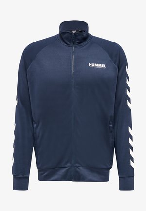 Giacca a zip navy con colletto alto, tessuto morbido, tasche laterali e strisce diagonali bianche sulle maniche. Presenta il logo sul petto.