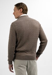 Bruine cable-knit trui met een hoge kraag, geribbelde manchetten en zoom. Textuur, nauwsluitend ontwerp met een klassieke uitstraling.