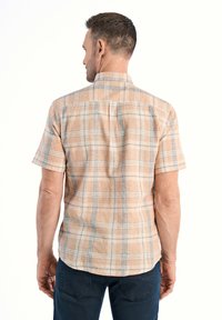 Korte mouwen, geruite shirt in lichte oranje en blauwe tinten. Lichtgewicht stof met een relaxte pasvorm en details op de rug.