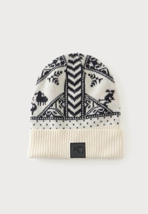 Bonnet blanc tricoté avec des motifs nordiques noirs comprenant des animaux, des formes géométriques, et un revers côtelé plié avec un patch logo noir.