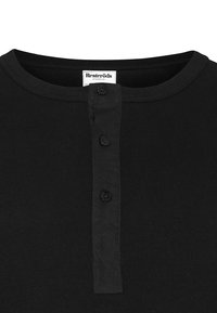 Svart ribbad Henley-tröja med tre svarta knappar vid halsringningen och synlig vit logotyp inuti kragen.