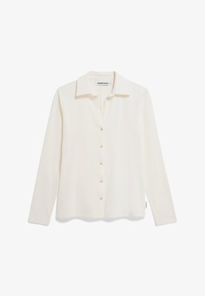 White long-sleeve blouse with a collar, button front closure, soft texture, and a straight hem. Features minimal branding on the side.