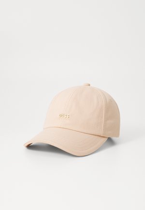 Baseball cap in soft beige fabric. Features a curved brim and a gold-colored "BOSS" logo on the front. Simple design, smooth texture.