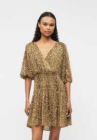 Hnědý šaty se zvířecím vzorem vyrobené z lehké tkaniny. Mají výstřih do V, krátké nabírané rukávy a smockovaný pas s splývavou sukní.