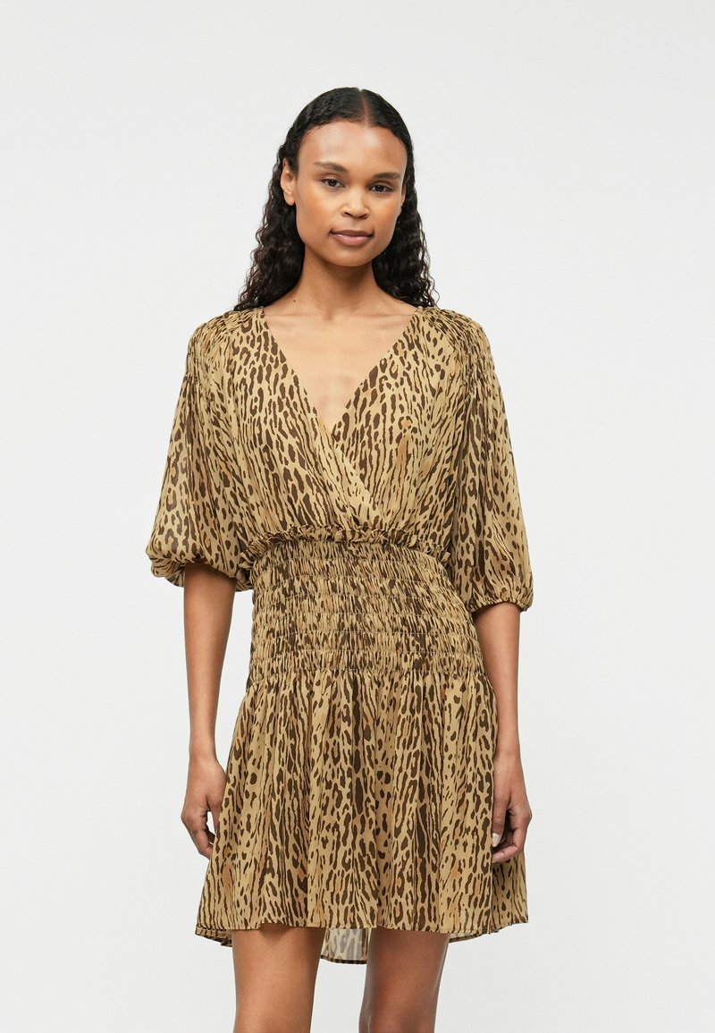 Hnědý šaty se zvířecím vzorem vyrobené z lehké tkaniny. Mají výstřih do V, krátké nabírané rukávy a smockovaný pas s splývavou sukní.