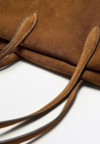 Brown suede tote bag with smooth texture, featuring two flat handles and contrasting stitching, designed for a simple yet functional look.