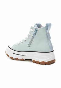 Sneaker high-top in tela blu chiaro con una cerniera laterale, lacci bianchi e una suola spessa bianca e marrone. Presenta un manico sul retro.
