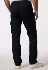 Námořnické cargo kalhoty s dvěma bočními kapsami a zadními kapsami, s rovnými nohavicemi a hladkým textilním povrchem. Nalezené v kombinaci s bílými teniskami.