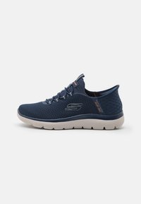 Navy blue athletic shoe with a textured mesh upper, elastic laces, and a lightweight white sole. Features a patterned rear and logo detail.