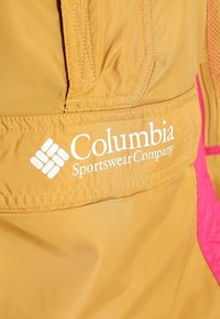 Giacca leggera gialla con accenti rosa. Presenta il logo "Columbia Sportswear Company" in bianco. Tessuto liscio e materiale resistente.
