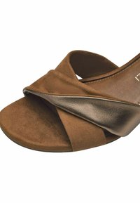 Brown suede slide sandal with crossed straps and a metallic accent. Rounded toe and low heel, featuring a textured insole.