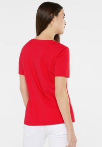 Red short-sleeve t-shirt made of soft cotton, featuring a classic crew neck and a relaxed fit, with smooth texture and no visible patterns.
