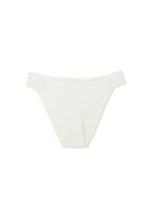 Slip in bikini bianco con dettagli in pizzo sul girovita. Presenta una texture liscia e un design semplice, che offre una copertura minimale.