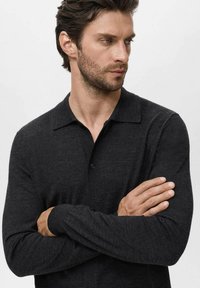Dark grey long-sleeve polo shirt featuring a collar, button closure, and soft texture. The fit is slightly tailored, with subtle seams.