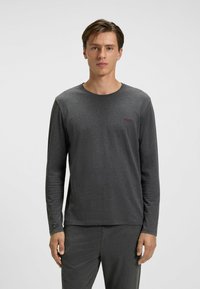 Grijs T-shirt met lange mouwen, gemaakt van zachte stof, met een ronde hals en een merklogo op de borst, gecombineerd met bijpassende grijze broek.