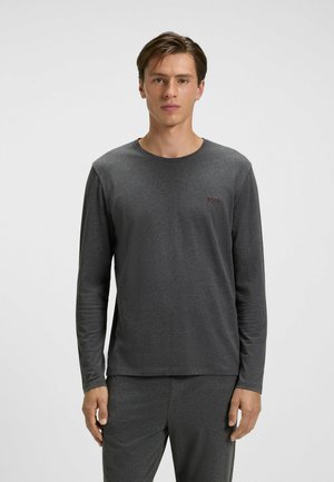 Long-sleeve gray t-shirt made of soft fabric with a round neck and branded logo on the chest, paired with matching gray pants.